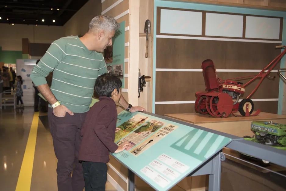 Father and son admiring display with trade literature in Technology in Our Lives Gallery