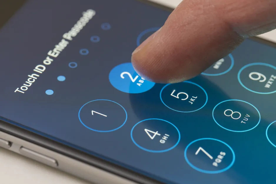 Finger pressing the number two to set a password on a smartphone  