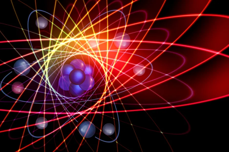 Représentation graphique colorée d’un atome sur un fond noir. Au milieu, on observe un noyau violet constitué de sept sphères, le tout entouré de sphères représentant des électrons avec des orbites dessinées en jaune, orange, rouge et bleu.  