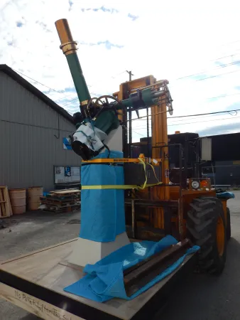  part of the green telescope being carried by a forklift
