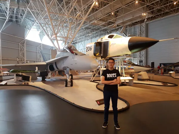 Victor Deng the student intern standing in front of the Avro Arrow and the CF-18