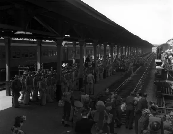 Image is a black-and-white photograph showing a large crowd of soldiers on a train platform at Bonaventure Station in Montreal.