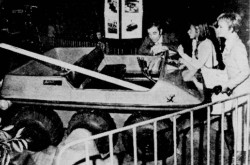 Charles Aznavour avec le véhicule tout-terrain Beehoo / Magna Amphicat qu’il examine, Montréal, Québec. Sa fille Seda est près de lui. Suzanne Piuze, « Aznavour m’a dit… » La Patrie, 25 janvier 1970, 20.