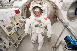  L'astronaute Chris Hadfield, portant une combinaison spatiale blanche et un casque.