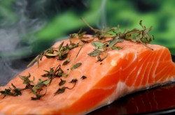 Close-up of a bright, fresh salmon steak with a garnish of herbs.