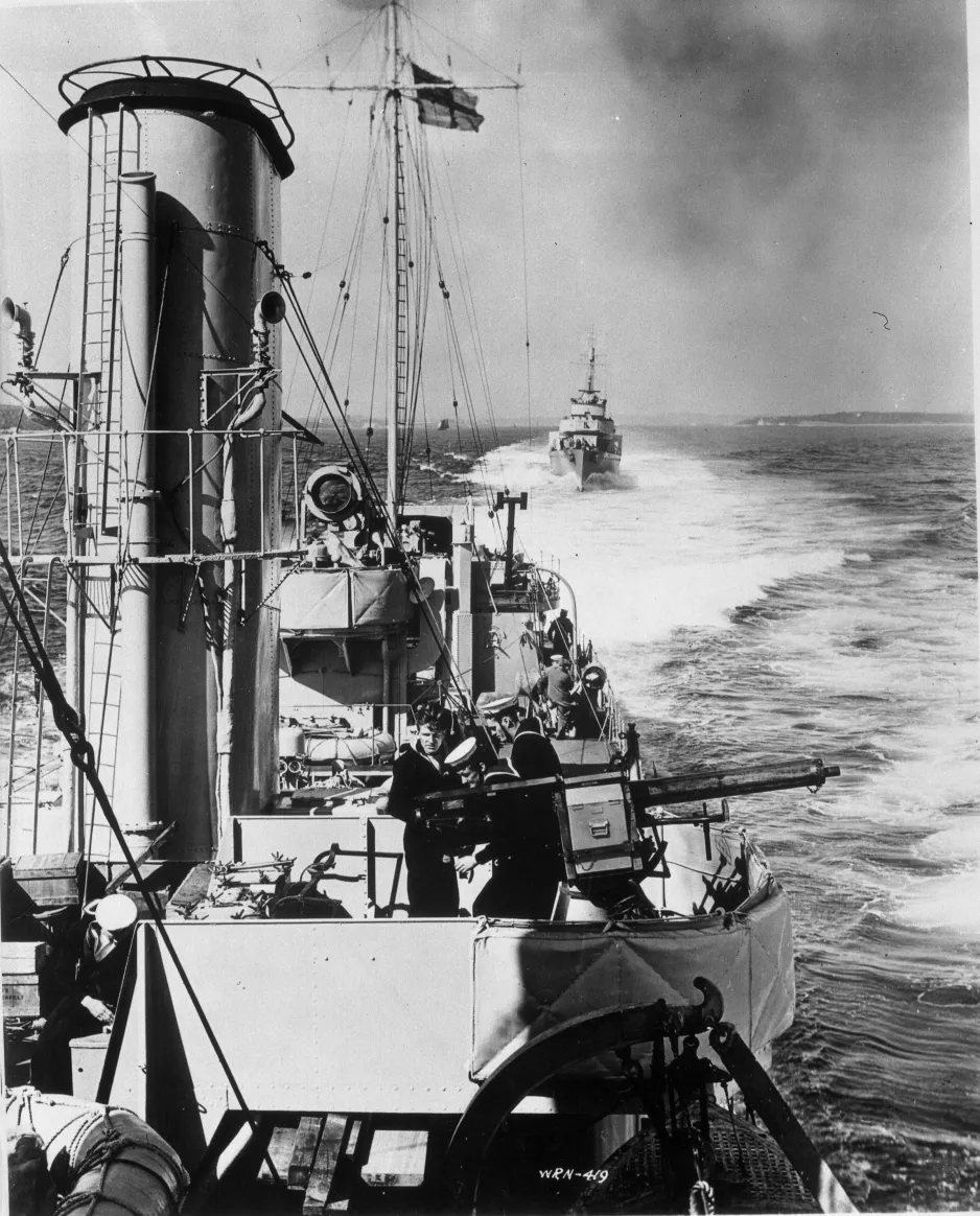 Canadian destroyers in line astern, steam out to sea to take up their positions in convoy, ca. 1942