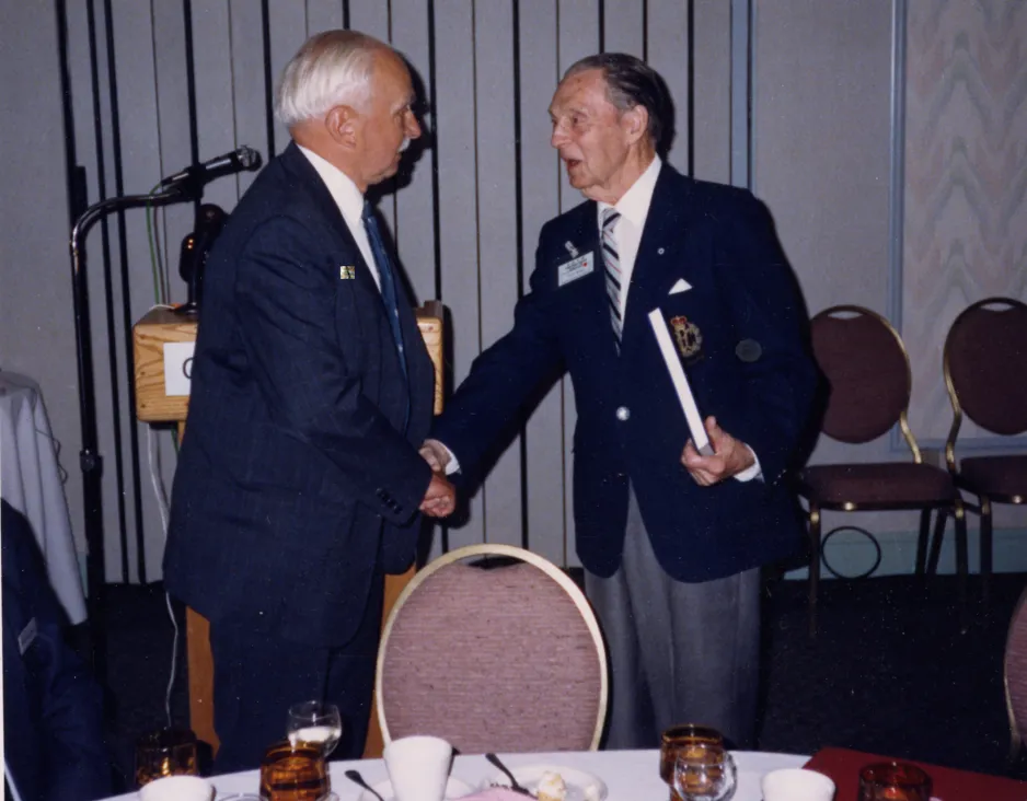 Le conservateur fondateur du Musée national de l’aviation, K.M. Molson, (à gauche) serre la main à Punch Dickins, un pionnier de l’aviation canadienne lors de la conférence de l’Association internationale des musées de transports, qui a eu lieu du 26 au 30 septembre 1988.