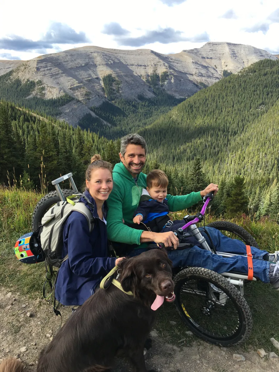 Christian Bagg et sa famille utilisent l'Icon Explore lors d'une randonnée dans un parc national de l'Alberta. On voit des montagnes et une vallée boisée en arrière-plan.
