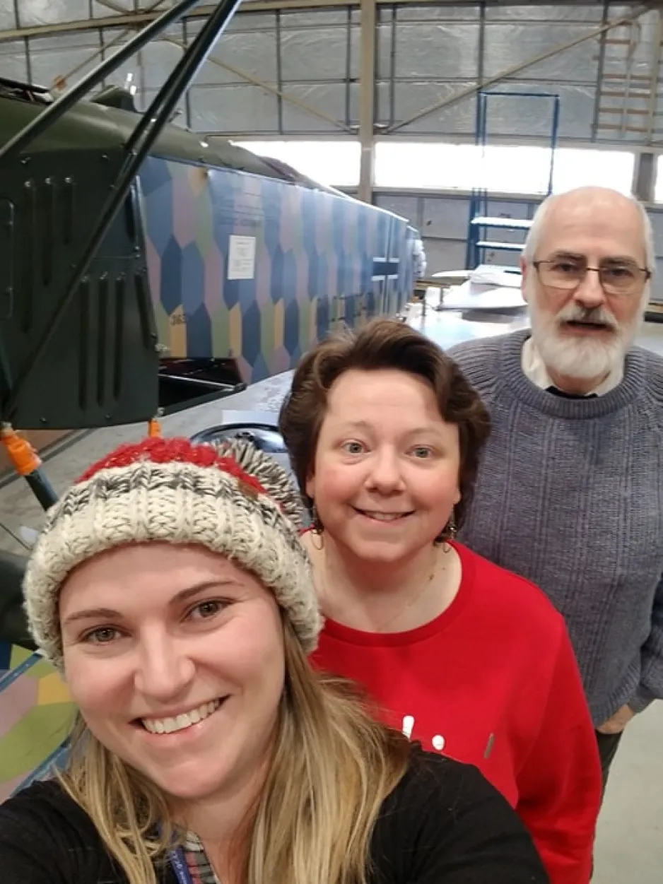 Museum staff members taking a “selfie” in front of the Fokker D.VII airplane.