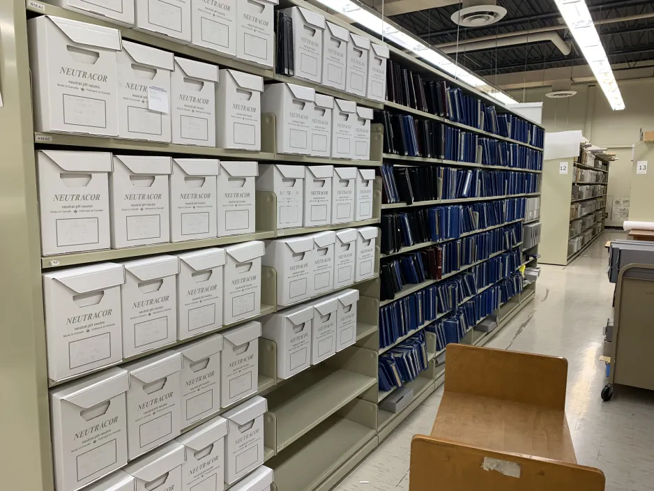 Seven rows of shelving units; the first two sections of shelving have boxes, the next five sections have albums.]