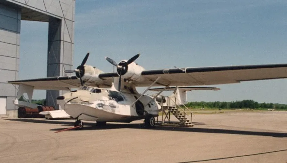 Cette photo présente l’aéronef PBY-5A Canso A de Consolidated à l’extérieur du Musée de l'aviation et de l'espace du Canada. Le dessous de l’appareil a des roues, mais ressemble à un bateau.