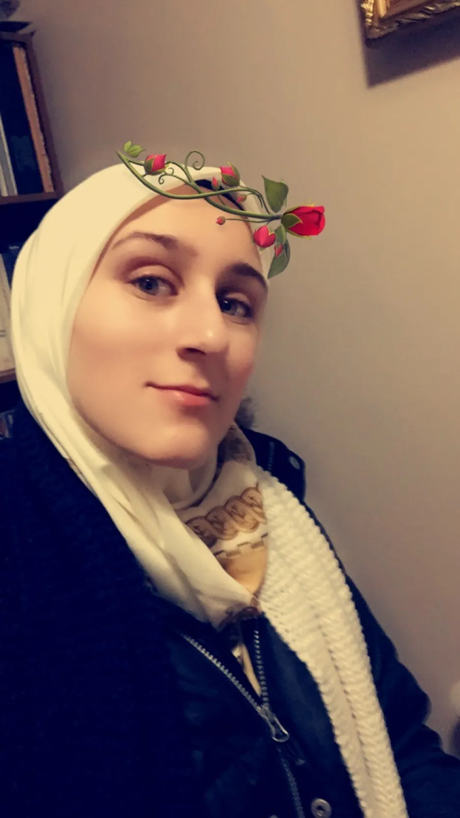 Image d’une jeune femme portant un manteau foncé et un hijab de couleur pâle. Une fleur graphique a été superposée à l’image.