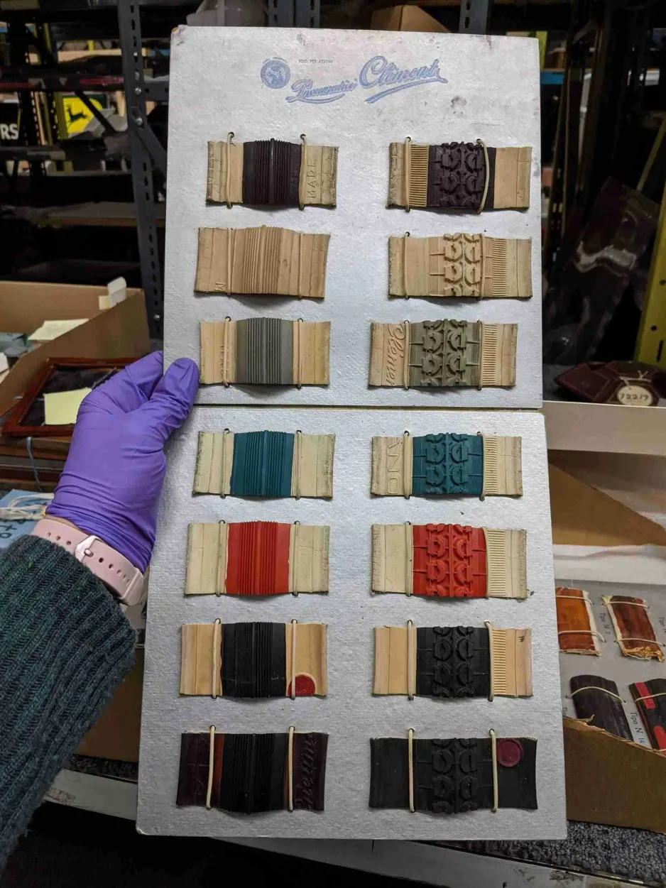 Une main gantée tient un carton d’échantillons de pneus de bicyclette en caoutchouc colorés provenant d’Italie et datant des années 1930.