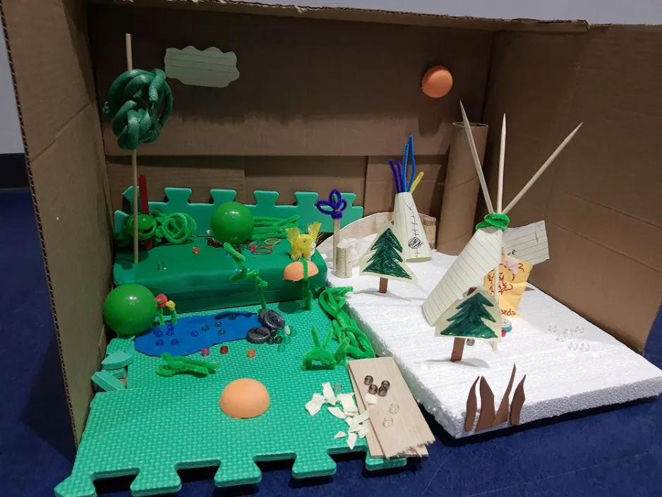 Model of an exhibition in a forest made from cardboard, foam, paper, sticks and pipe cleaners