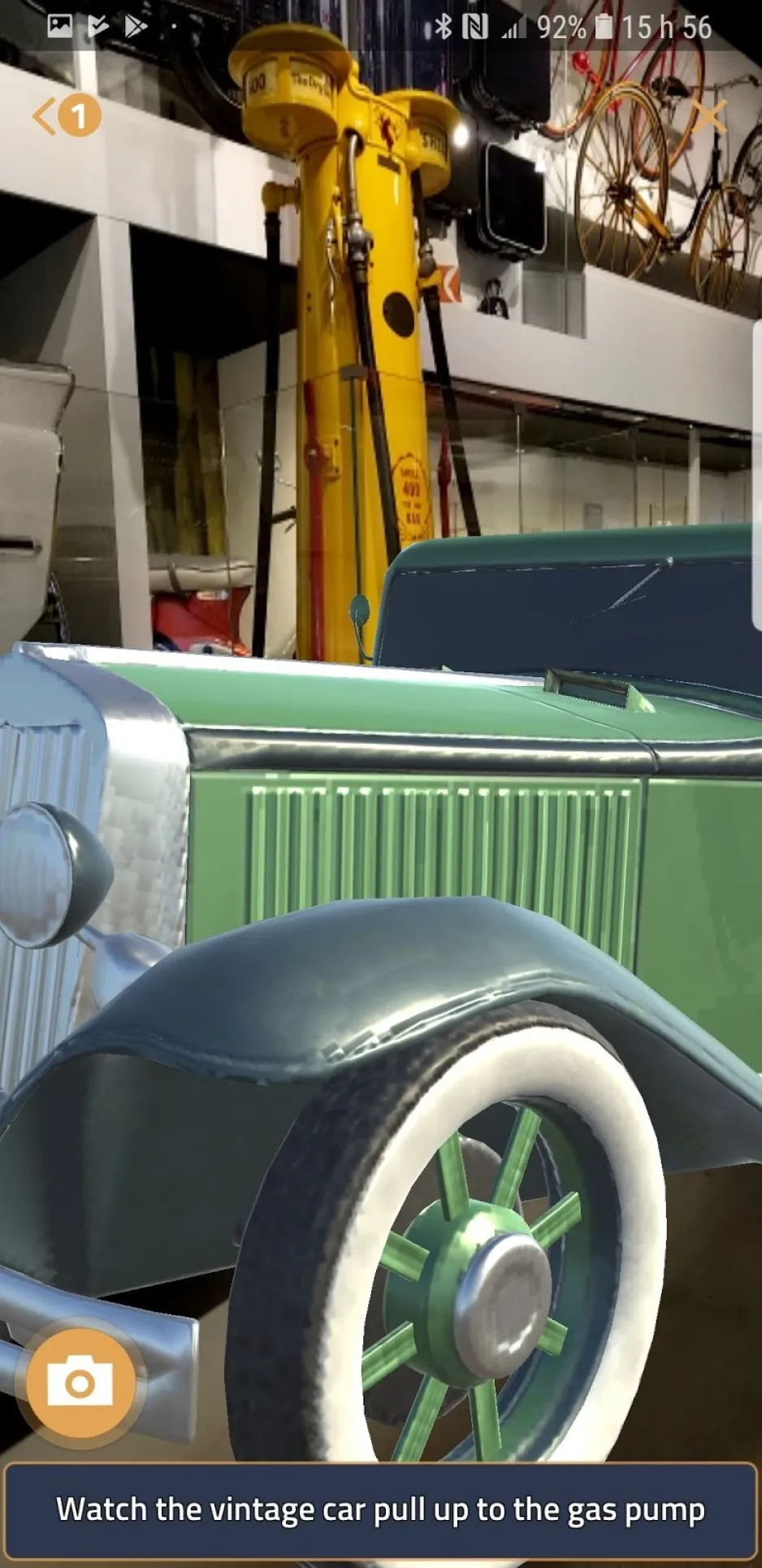 Une image animée d’une voiture d’époque verte apparaît sur l’écran d’un téléphone une fois que l’utilisateur a repéré la pompe à essence dans le Musée.