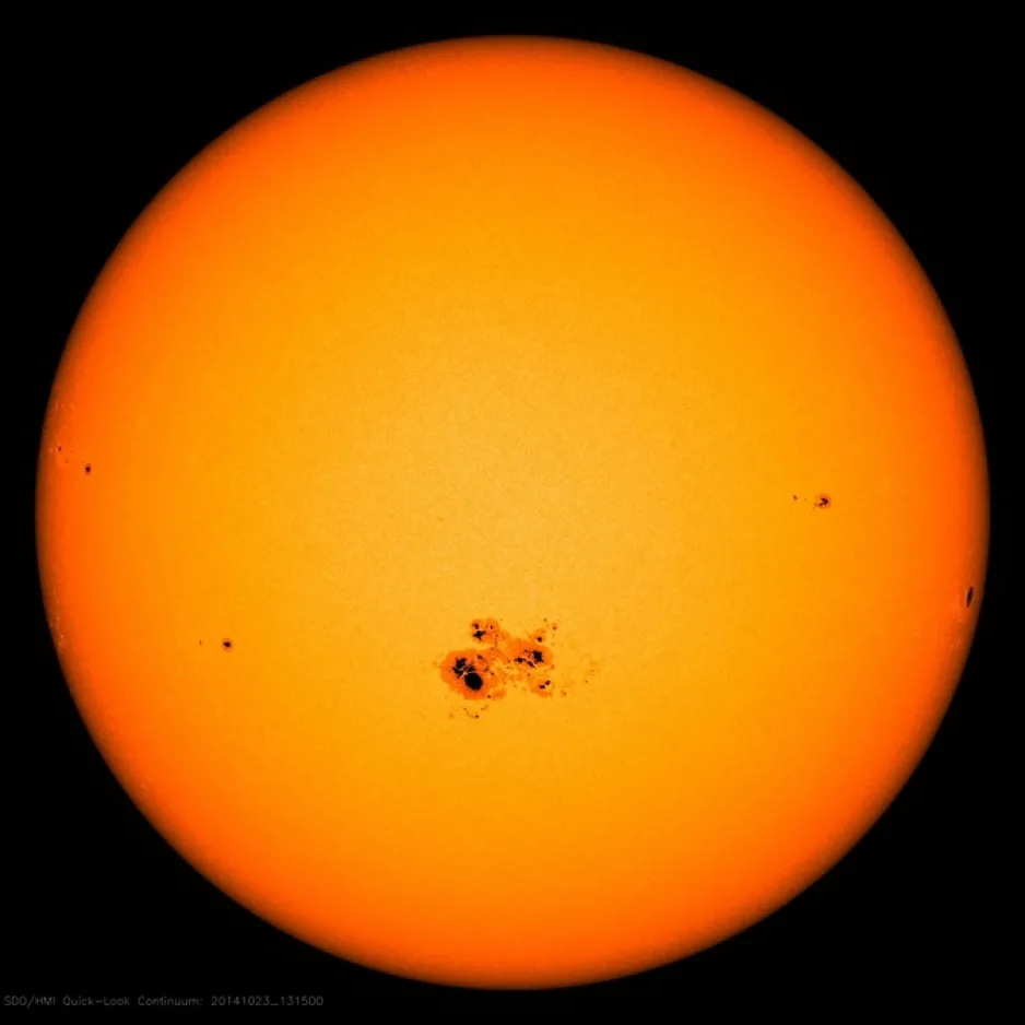 A close-up image of the Sun; the small black marks on it are sunspots.