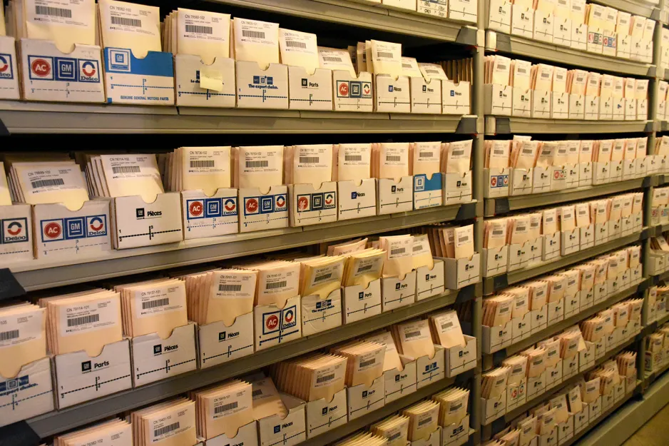 A view of shelves holding rows of boxes filled with beige envelopes. 