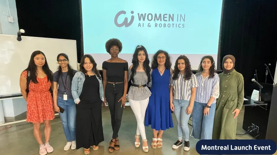Neuf femmes de différentes races sont alignées devant un écran de projection sur lequel on peut lire "Les femmes dans l'IA et la robotique".