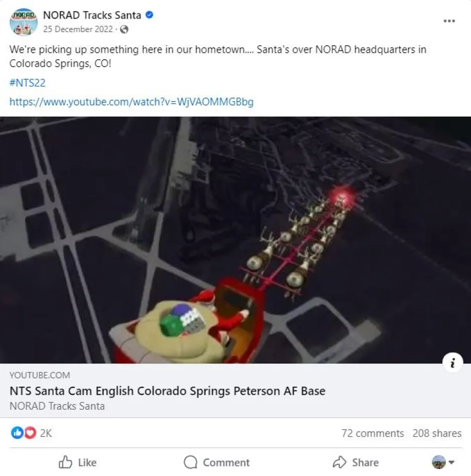 This is an image of a Facebook post from NORAD Tracks Santa. A computer animation shows Santa Claus and a large bag of presents in a red sleigh. The sleigh is pulled by a team of nine reindeer. They are flying over a military base whose runways are clearly visible below.