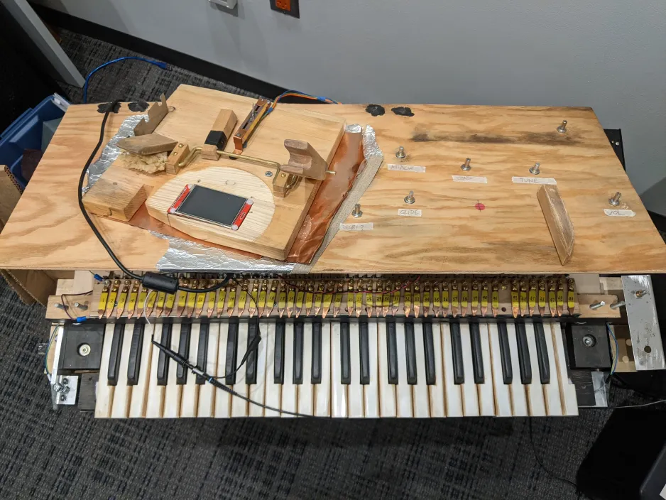 Overhead shot of the control surface and keyboard of the reconstructed instrument, with various knobs, wires, and a touchpad in view.