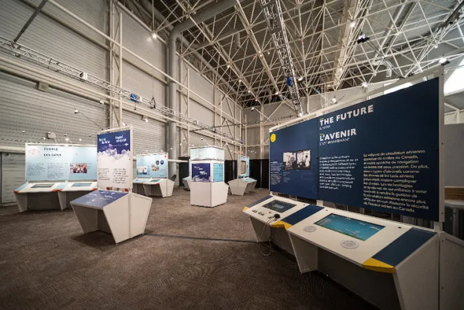 Une vue panoramique de l’exposition montrant de nombreux modules; l’ultime panneau, en avant-plan, porte les mots « L’avenir ».