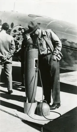 Hans Lundberg examinant le magnétomètre remorqué par un Beech Modèle 18 utilisé par U.S. Geological Survey, Rockcliffe, Ontario, 12 septembre 1946. MAEC, Coll. Spartan Air Services, numéro de négatif 35818.