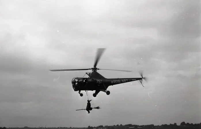A Westland Dragonfly of the Royal Navy’s Fleet Air Arm carrying a man dressed up as a witch for a special event, September 1962. CASM, Molson collection negative.