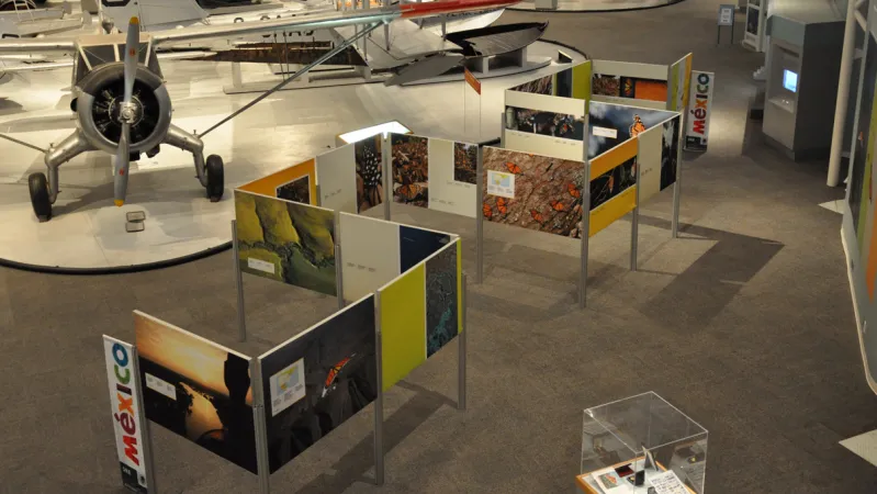 An aerial view of the exhibition shows the panels arranged in a zig-zag formation.