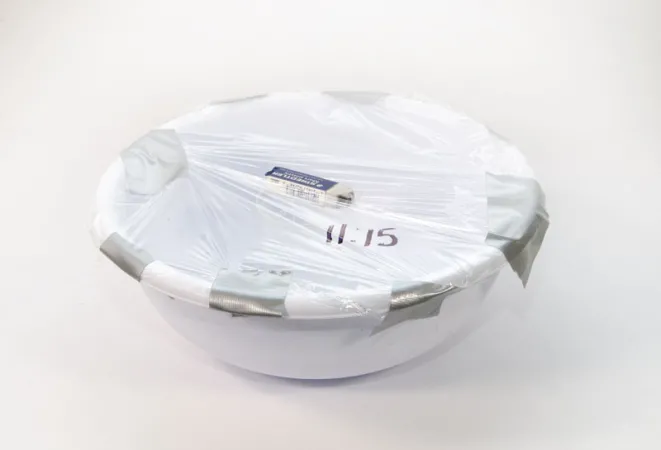 a bowl with saran-wrap on top and an eraser