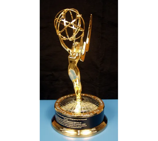 A shiny Emmy award sits on a blue table.