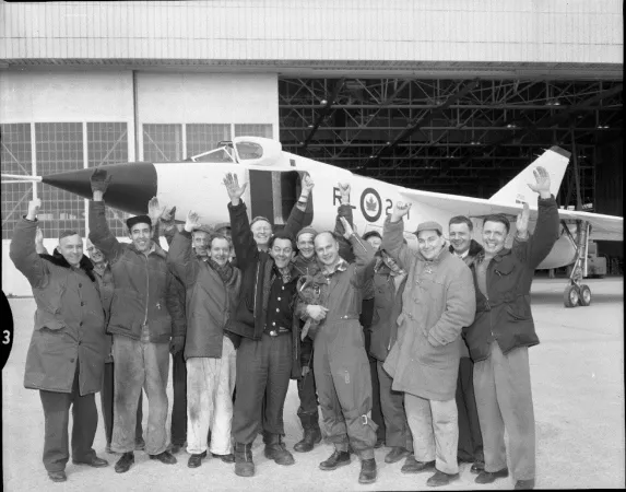 Photograph of pilot Jan Zurakowski and crew cheering in front of Avro Arrow RL-201