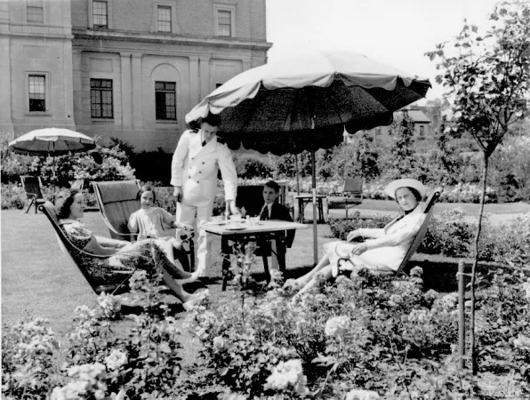 A family sitting on lawn furniture in the rose garden of the Nova Scotian hotel