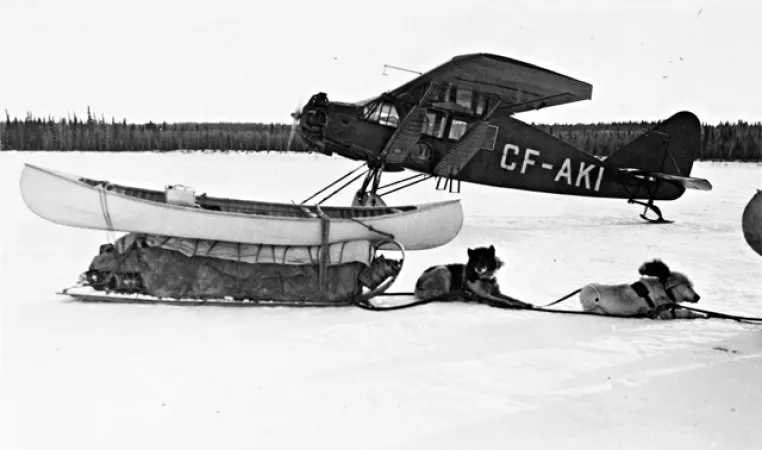 Bellanca CH-300 Pacemaker next to a kayak and a dog sled