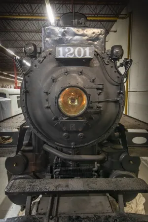 A head-on view of CP 1201, with its large headlight and “1201” sign.