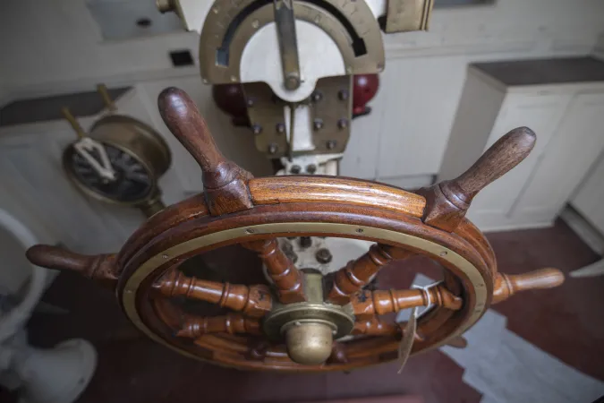A view of the solid-looking, wooden steering wheel, inside the pilot house from the SS Prince Edward Island.