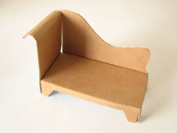 A miniature couch made out of cardboard 