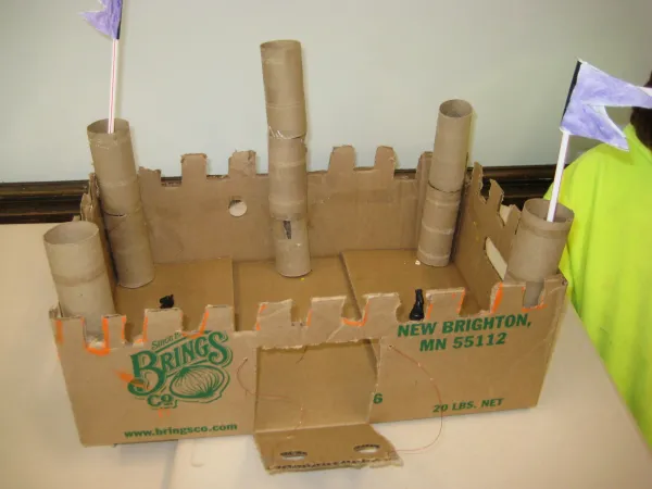 A toy castle constructed out of cardboard, toilet paper rolls, and straws 