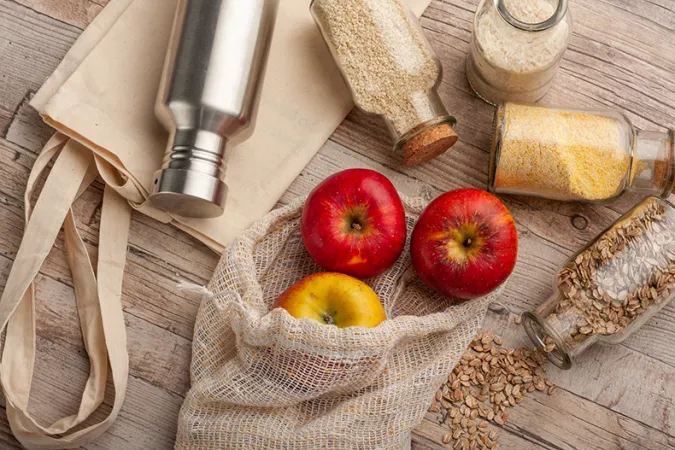 1)	Des pommes rouges et diverses céréales présentées dans des contenants réutilisables et des sacs de tissus.
