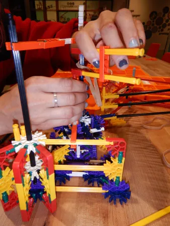 A museum guide in the process of building a super robust and complicated K’NEX catapult