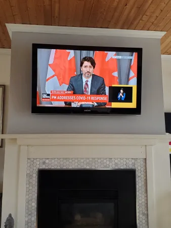 In a living room with a straight-on view of the Prime Minister of Canada on a television.