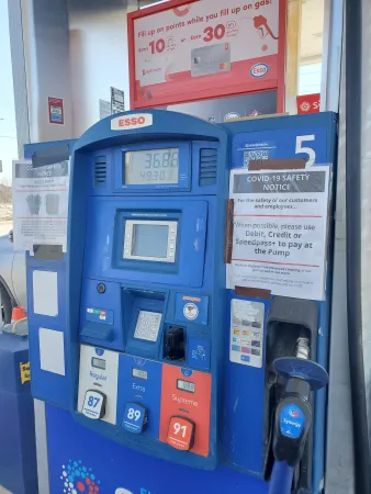 Public gas pump with warning signs relating to COVID-19