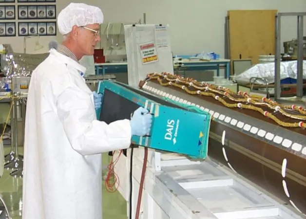 An Institute for Aerospace Research staff member conducting an inspection on a Shuttle Remote Manipulator System, or Canadarm, around 2000. National Research Council Canada.