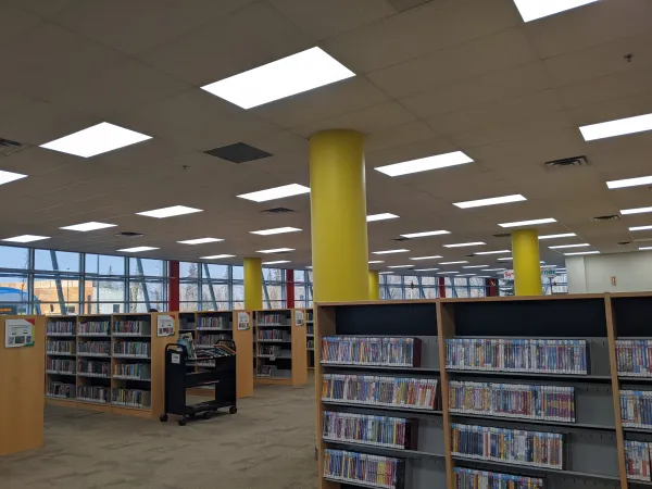 On voit des rangées d’étagères avec des poteaux jaunes ronds qui les relient au plafond. 
