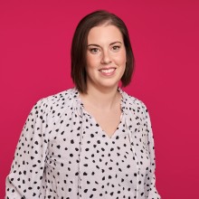 A headshot of Michelle in a white blouse with black polka dots