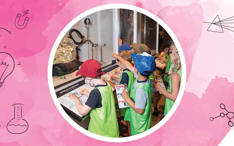  Des enfants portant des dossards verts se tiennent devant un élément d’exposition du Musée présentant des exemples de divers produits fabriqués avec du verre. Certains enfants pointent le tout alors que d’autres notent des renseignements sur une fiche d’activité.