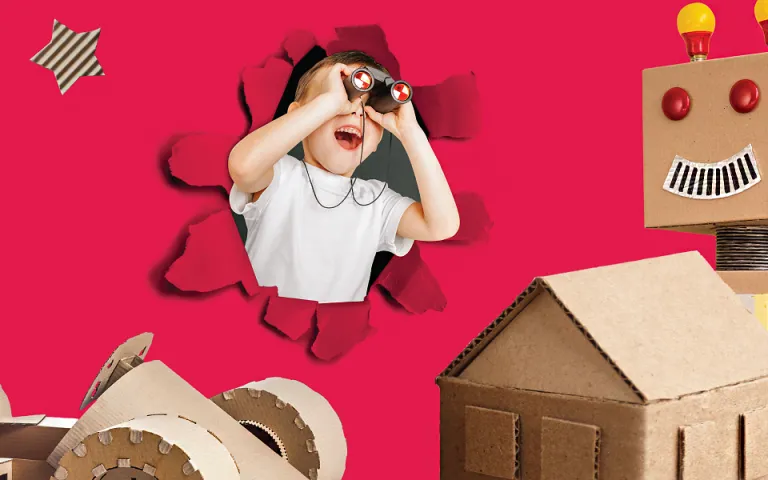 Un enfant souriant et regardant à travers des jumelles semble sortir de l’illustration d’une feuille de papier rouge uni déchiré. On voit une voiture de carton, une maison de carton et un robot de carton en avant-plan.