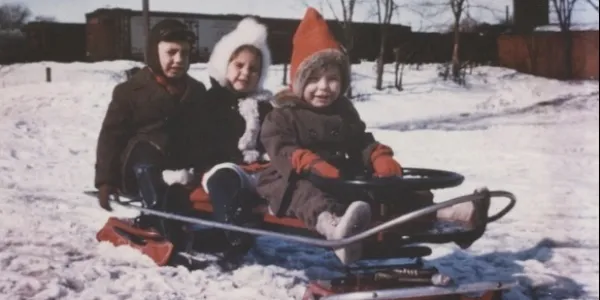 Three children sitting on the Dudley bobsled
