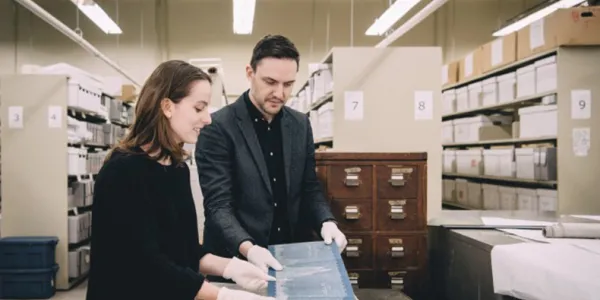 Master’s student Cristina Wood and curator Tom Everrett examine historical records in the museum’s archives