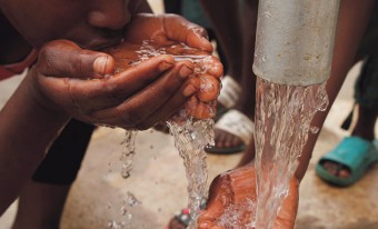 image of a boy drinking fresh water from his hands
