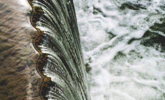 Water falling from a dam. Close view from above.
